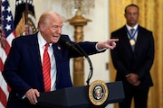 President Donald Trump speaks as Pro-golfer Tiger Woods listens during a reception for Black History Month in the East Room of the White House on Thursday, Feb. 20, 2025